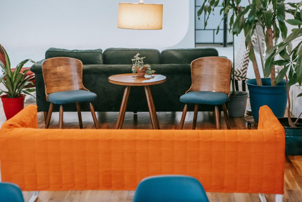 A stylish modern living room featuring wooden furniture and vibrant plants, creating a cozy ambiance.