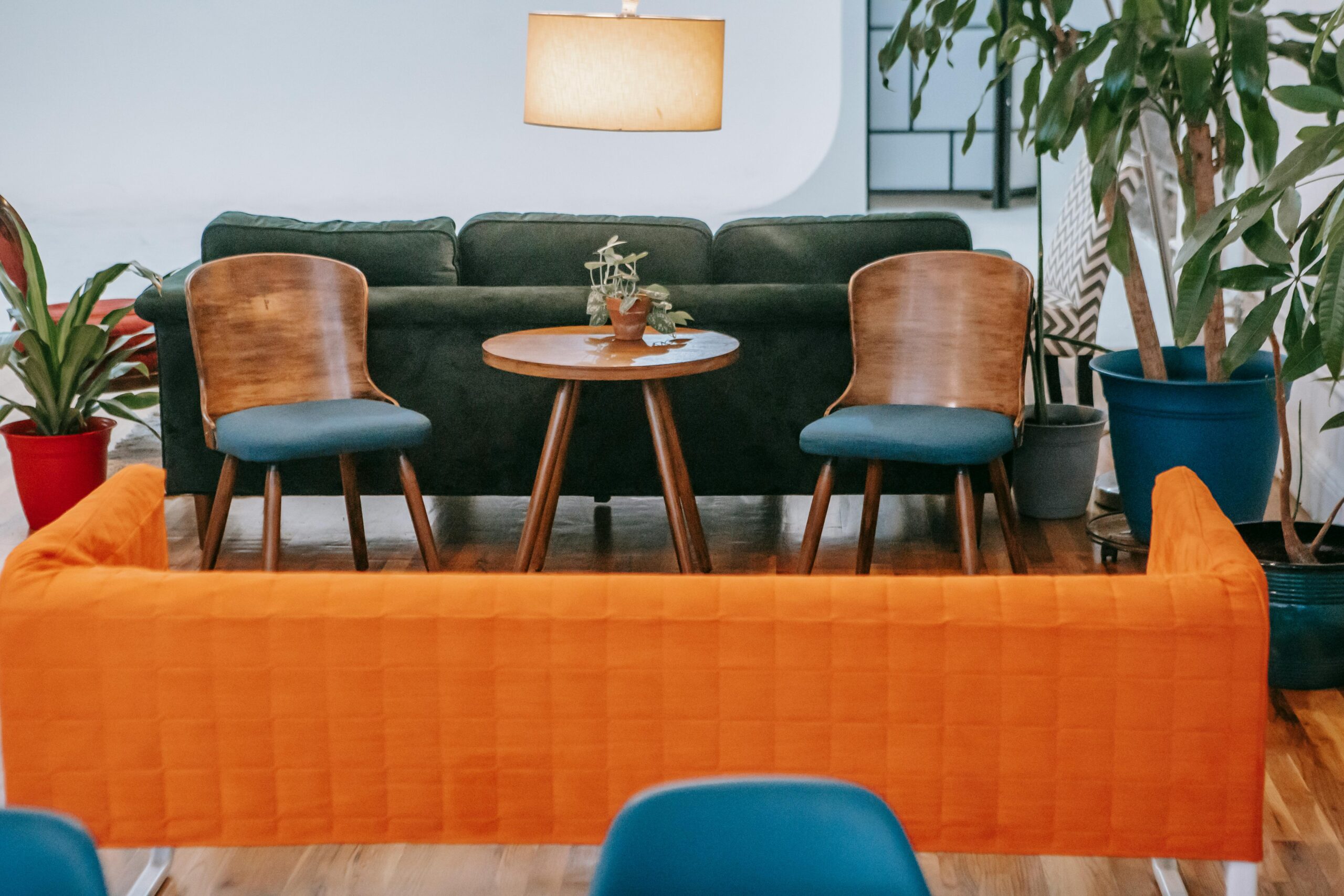 A stylish modern living room featuring wooden furniture and vibrant plants, creating a cozy ambiance.