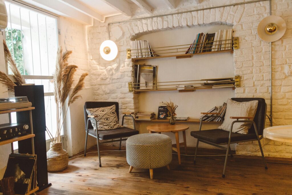 vintage style living room with two chairs, centre table, wall ingrooved book shelf, window